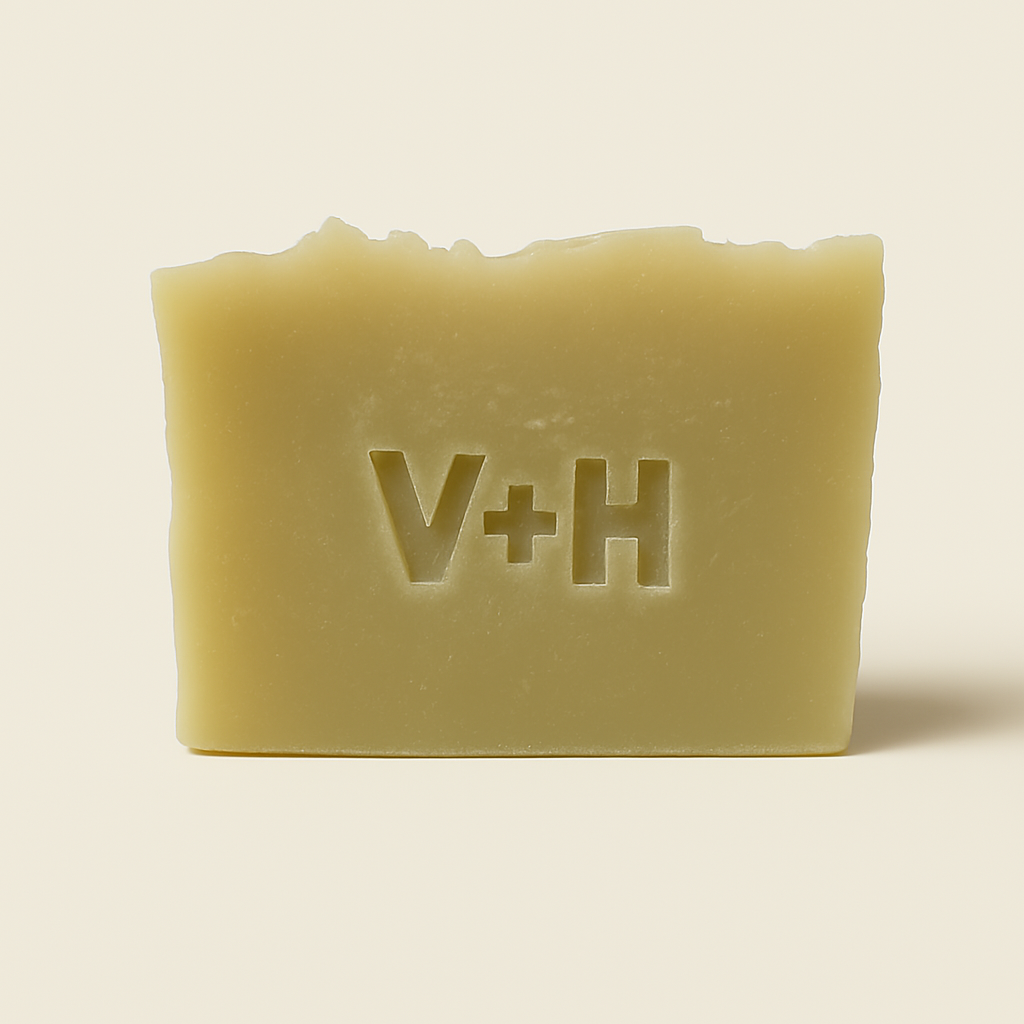 Front view of handmade natural tea tree soap bar with 'V+H' initials elegantly embossed into the surface.