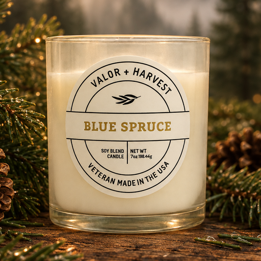 Valor+Harvest Blue Spruce soy blend candle in a glass jar with pine needles and pinecones.