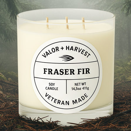 Candle labeled 'Fraser Fir' in a forest setting