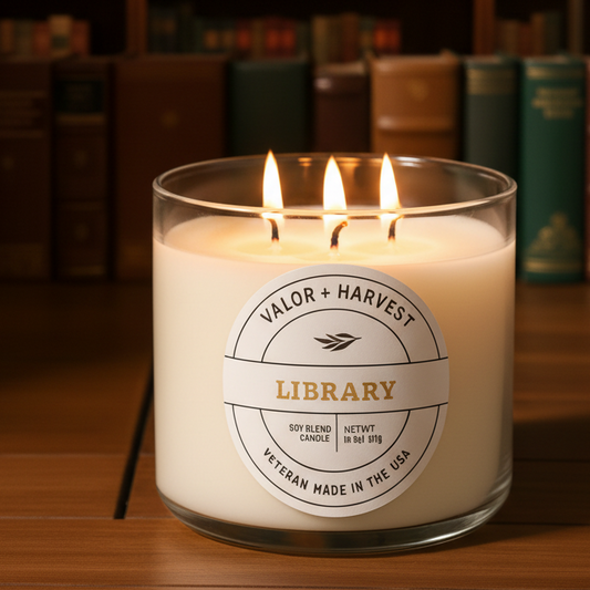 Valor+Harvest Library 3-wick soy blend candle lit in front of a blurred bookshelf.