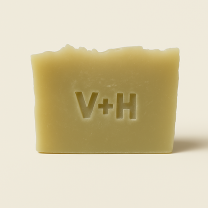 Front view of handmade natural tea tree soap bar with 'V+H' initials elegantly embossed into the surface.