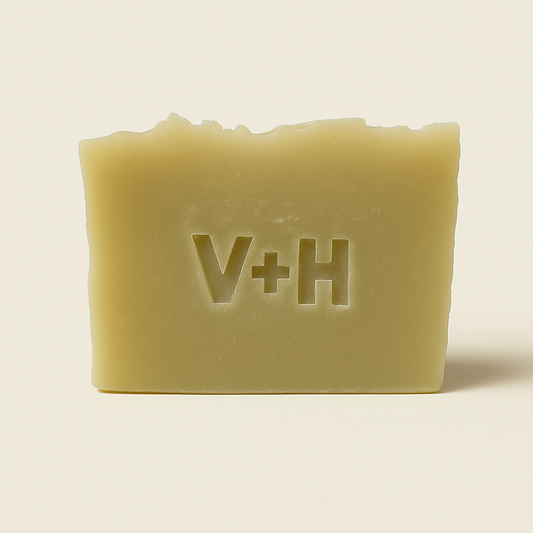 Front view of handmade natural tea tree soap bar with 'V+H' initials elegantly embossed into the surface.