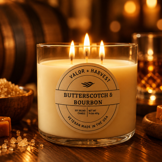 Valor+Harvest Butterscotch & Bourbon 3 wick soy blend candle lit on a rustic wooden table.