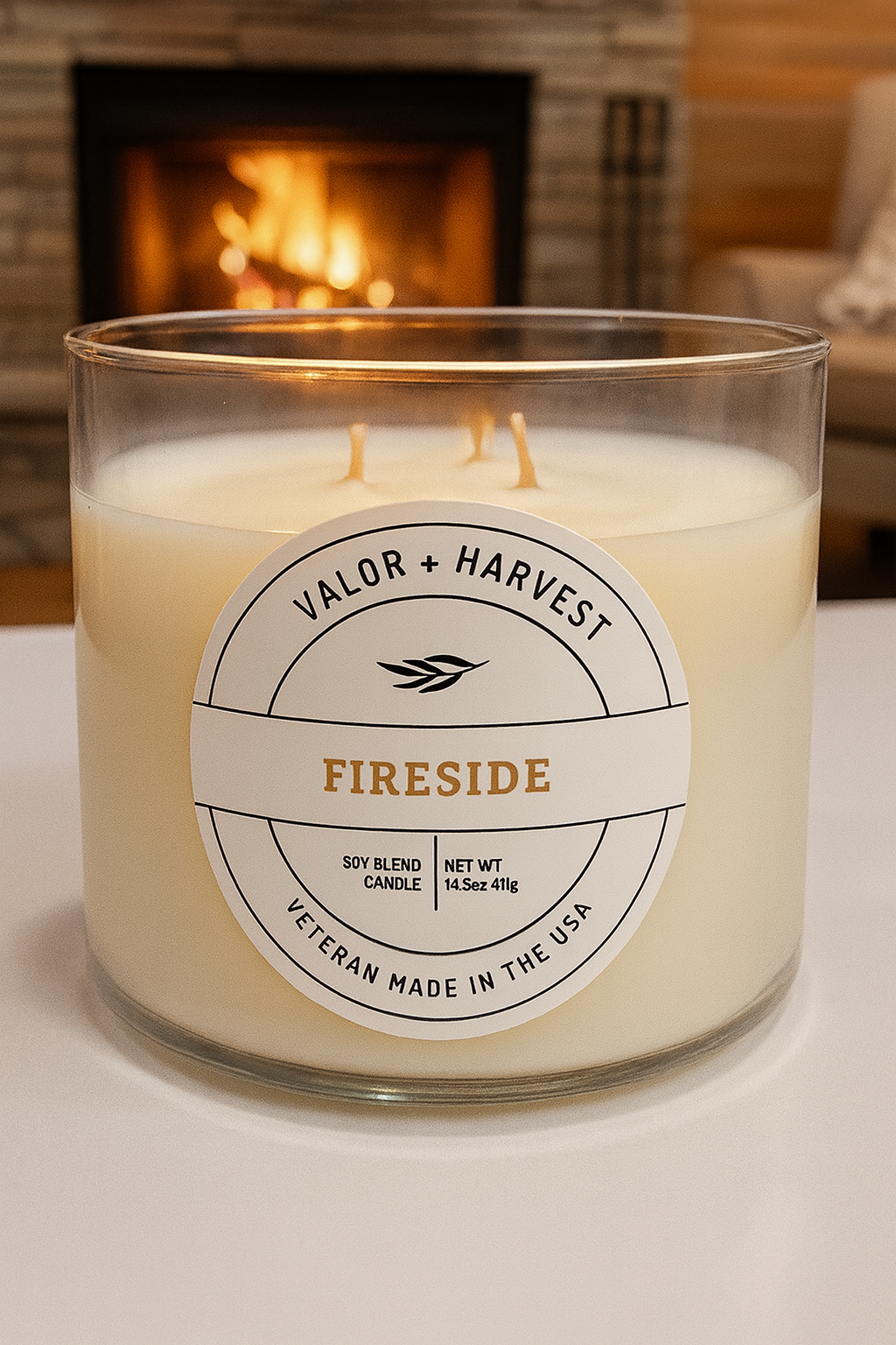 Candle labeled 'Valor + Harvest Fireside' in front of a fireplace