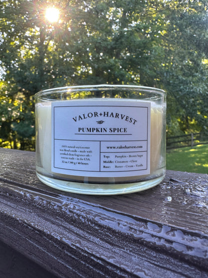 Valor+Harvest Pumpkin Spice soy wax candle in a clear glass jar outdoors at sunset.